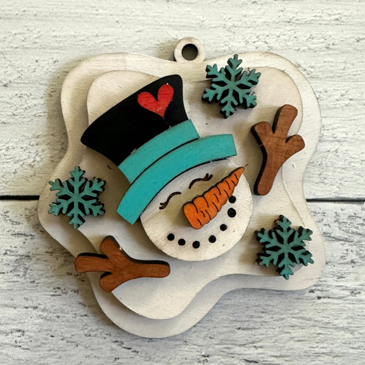 Wooden snowman ornament with a heart on top hat on a light wooden background