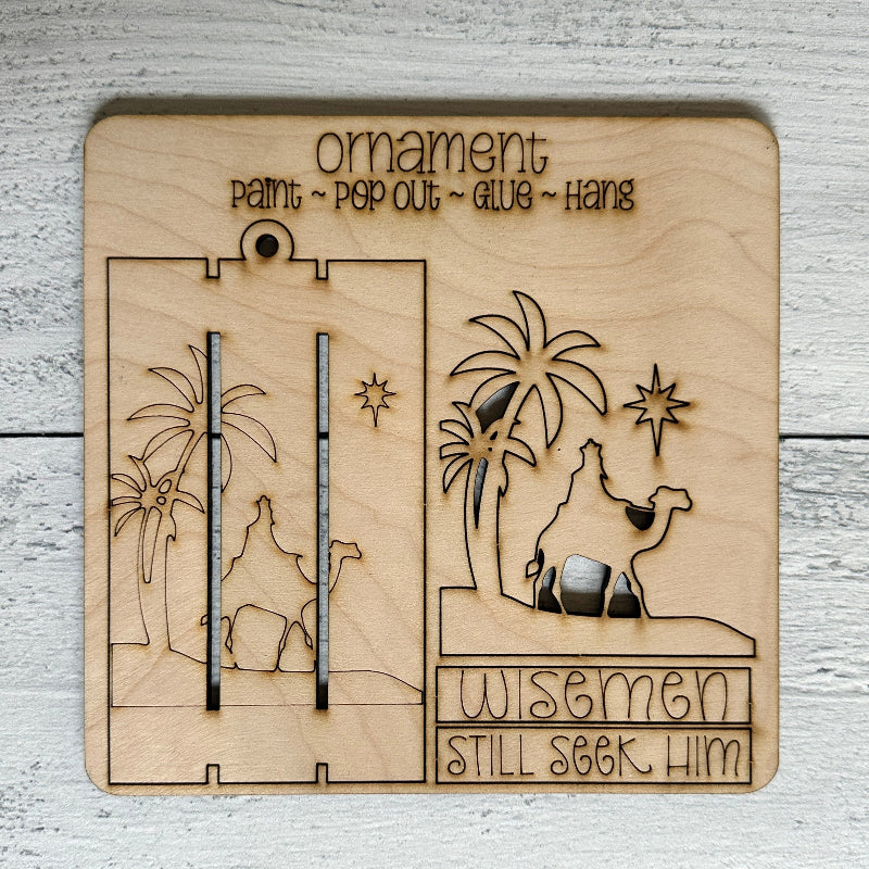 Wooden nativity scene ornament with 'Wisemen Still Seek Him' text on a light wooden background